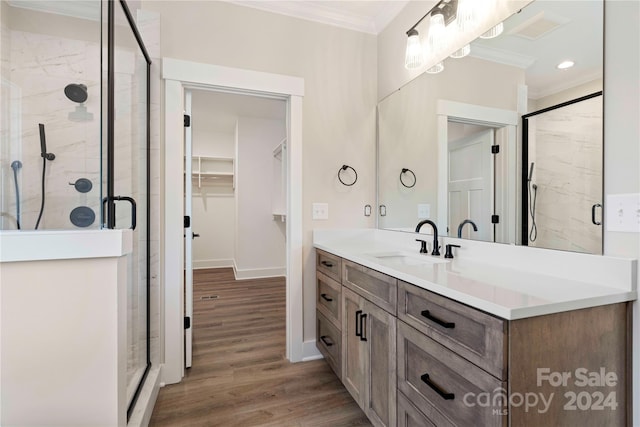 bathroom featuring walk in shower, crown molding, vanity, and hardwood / wood-style flooring