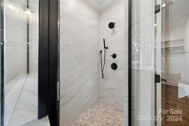 bathroom with crown molding and tiled shower