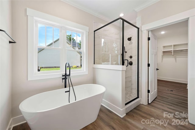 bathroom with hardwood / wood-style floors, shower with separate bathtub, and crown molding