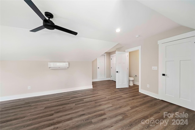 additional living space with ceiling fan, lofted ceiling, dark wood-type flooring, and a wall unit AC