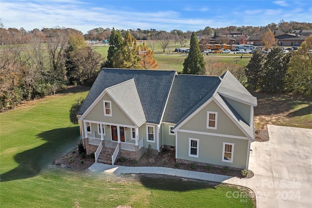 view of front of home with covered porch and a front lawn