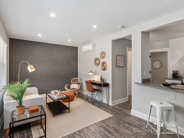 living room with brick wall, a wall mounted AC, and dark hardwood / wood-style flooring