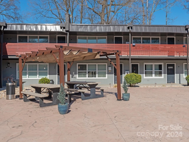 back of property featuring a pergola and a patio area