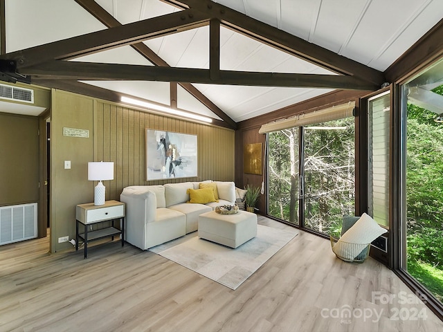 living room featuring wooden walls, beam ceiling, high vaulted ceiling, and hardwood / wood-style flooring