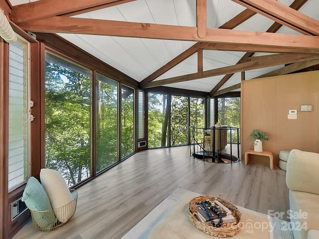 sunroom / solarium featuring plenty of natural light and vaulted ceiling with beams