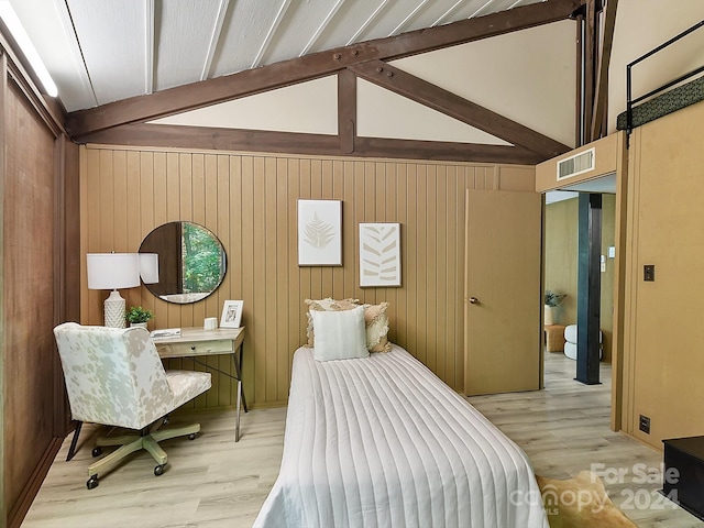 bedroom featuring light hardwood / wood-style flooring, vaulted ceiling with beams, and wooden walls