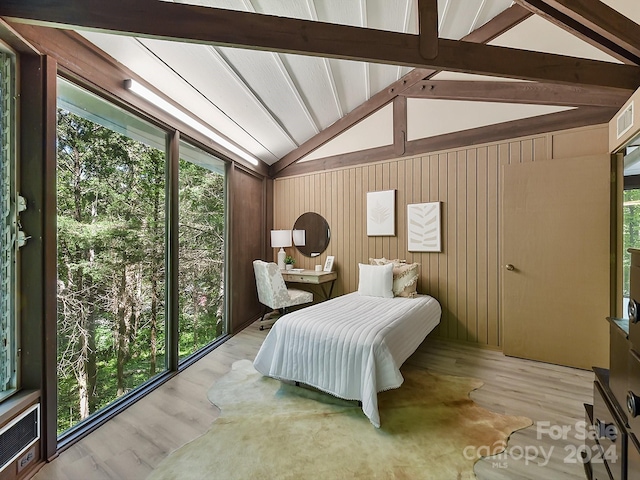 bedroom with vaulted ceiling with beams, wood-type flooring, and wooden walls