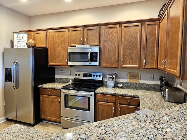 kitchen with stainless steel appliances and light stone countertops