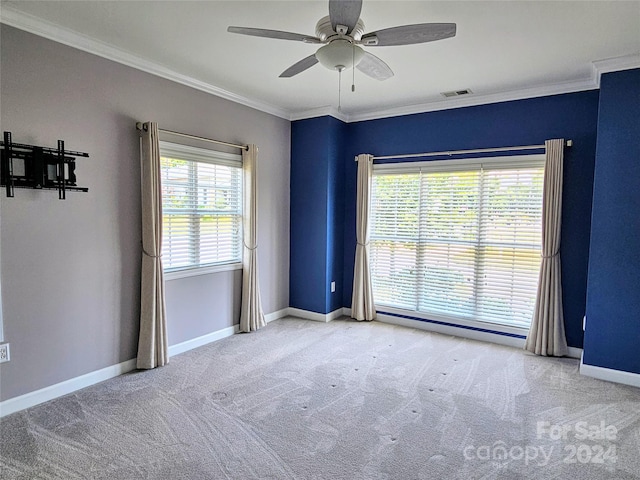 carpeted spare room featuring ceiling fan and ornamental molding