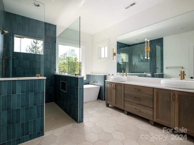 bathroom with tile walls, tile patterned flooring, vanity, and separate shower and tub