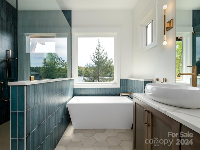 bathroom with tile walls, vanity, and plenty of natural light