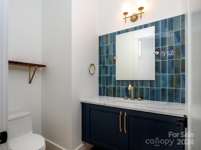 bathroom featuring decorative backsplash, vanity, and toilet