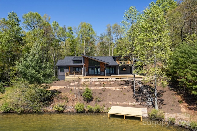 rear view of house featuring a deck with water view