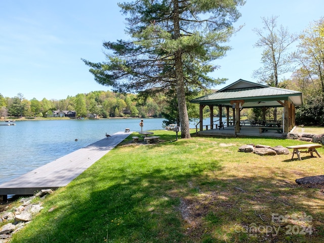 dock area with a water view, a gazebo, and a yard