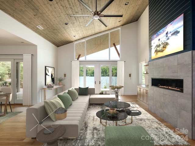 living room with wood ceiling, a towering ceiling, ceiling fan, and a fireplace