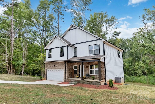 view of front of property with a garage, a porch, and a front lawn