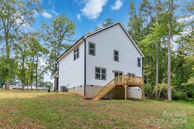 back of property featuring a deck, a yard, and central AC