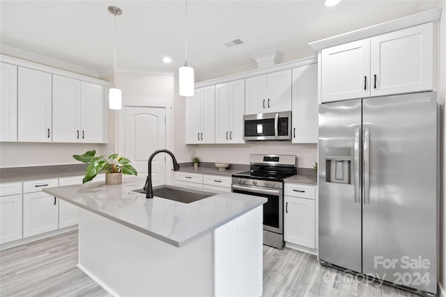 kitchen featuring white cabinets, appliances with stainless steel finishes, decorative light fixtures, and sink