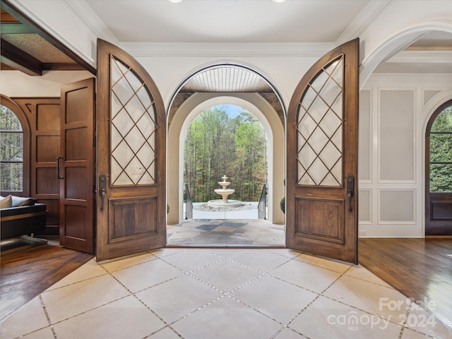 tiled entrance foyer featuring ornamental molding