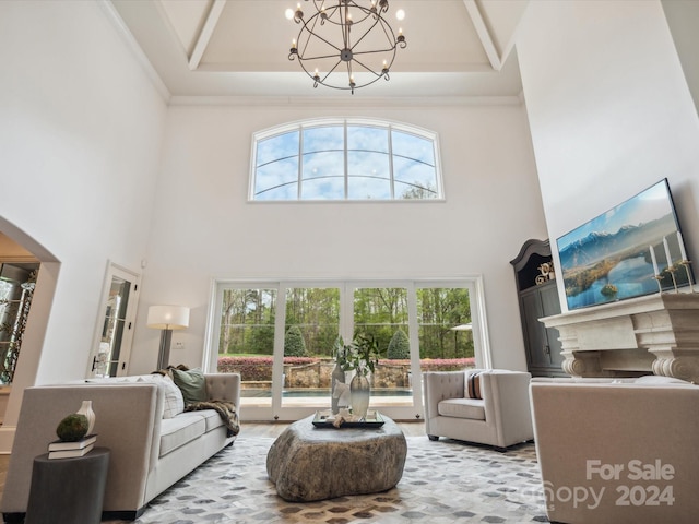 living room featuring a wealth of natural light, a notable chandelier, a tray ceiling, and a high ceiling