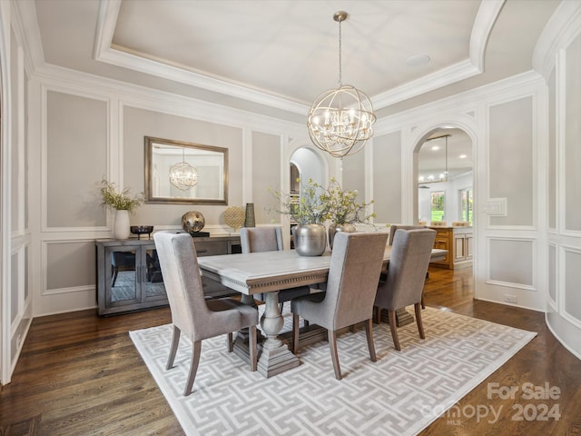 dining room with a raised ceiling, dark hardwood / wood-style flooring, and a notable chandelier