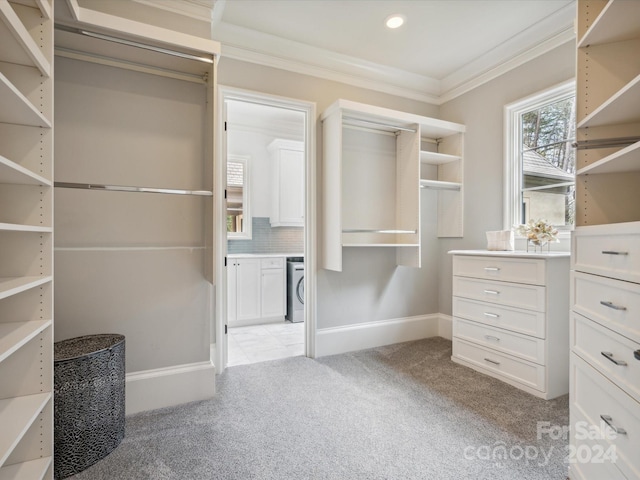 spacious closet with washer / clothes dryer and light carpet