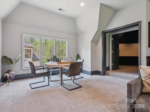 dining area featuring vaulted ceiling and carpet floors