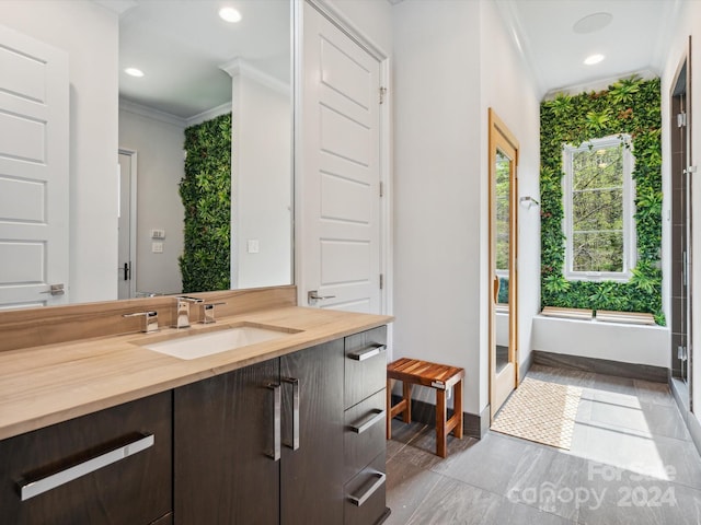 bathroom featuring ornamental molding, a healthy amount of sunlight, tile floors, and vanity