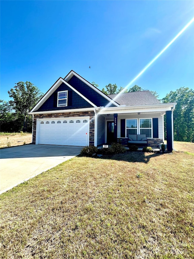 view of front of house with a garage, a porch, and a front lawn