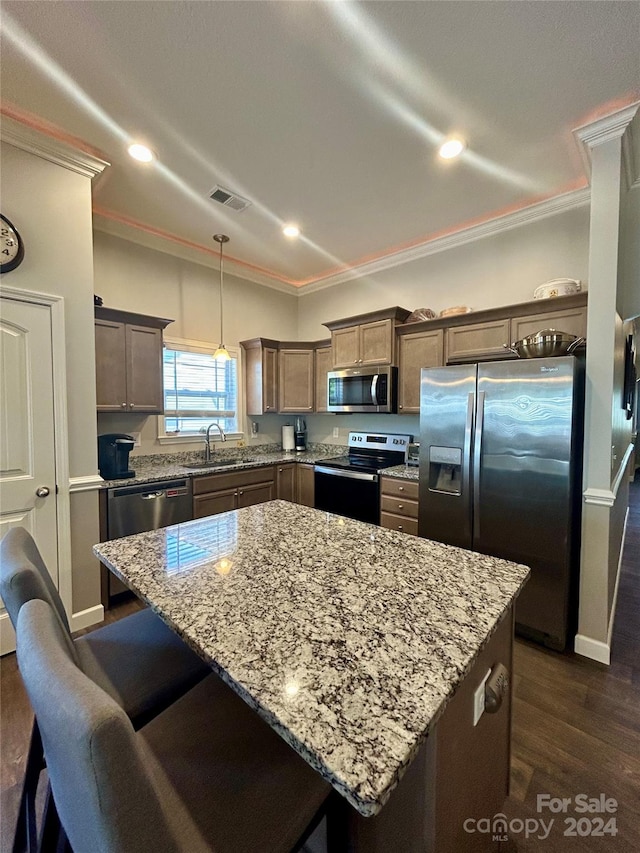 kitchen with ornamental molding, a center island, stainless steel appliances, and dark hardwood / wood-style floors