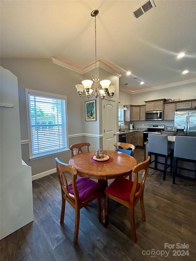 dining space featuring vaulted ceiling, dark hardwood / wood-style flooring, crown molding, and an inviting chandelier