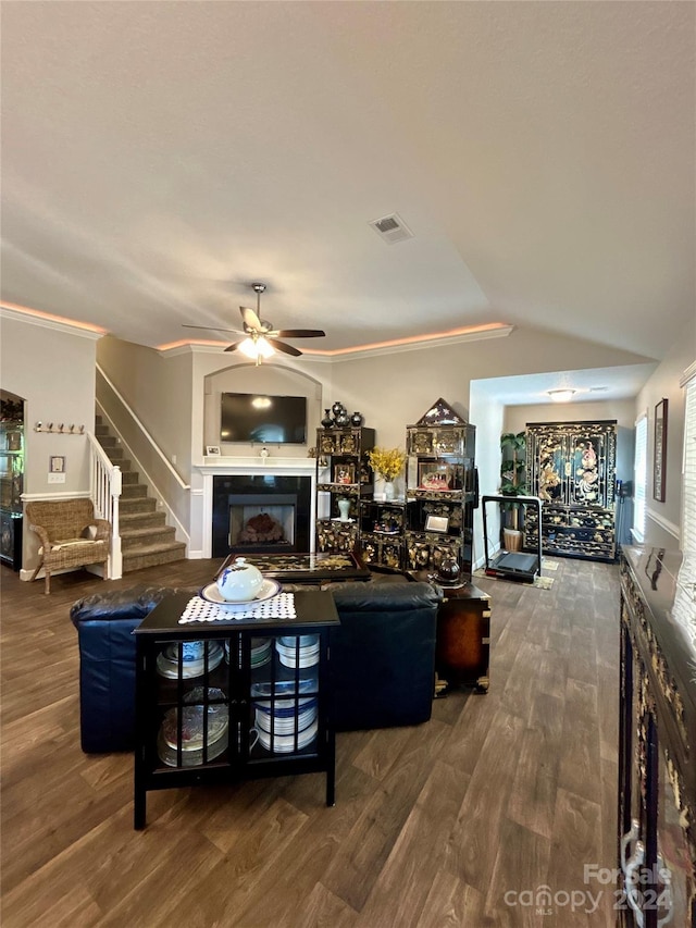 living room featuring ornamental molding, wood-type flooring, ceiling fan, and a tile fireplace