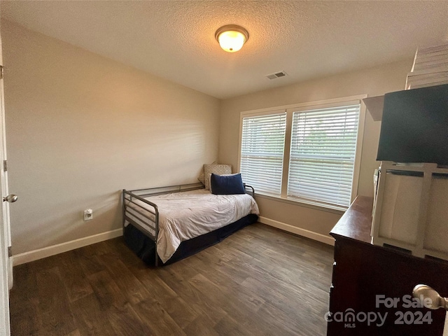 bedroom featuring dark wood-type flooring and a textured ceiling