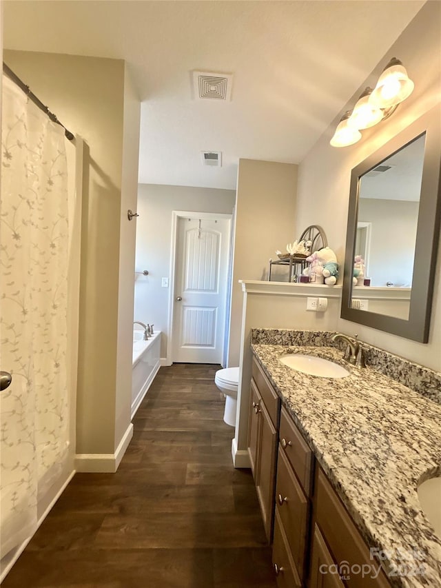 bathroom featuring wood-type flooring, toilet, and large vanity