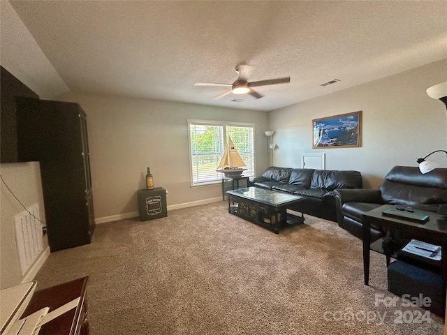 carpeted living room featuring ceiling fan and a textured ceiling