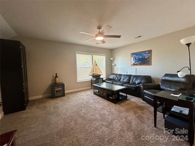 living room featuring a textured ceiling, ceiling fan, and carpet