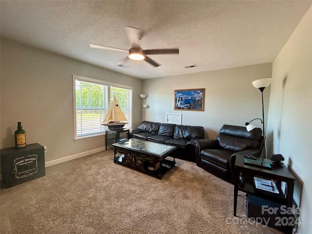 living room with ceiling fan, carpet floors, and a textured ceiling