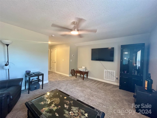 carpeted living room with ceiling fan and a textured ceiling