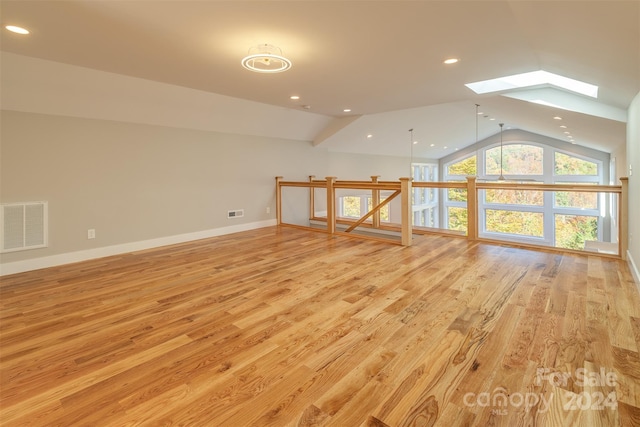 bonus room featuring lofted ceiling with skylight and light wood-type flooring