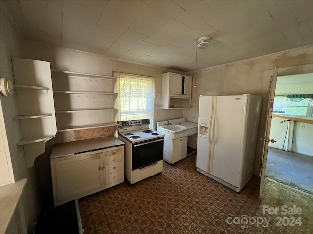 kitchen with tile flooring, sink, white appliances, and white cabinetry