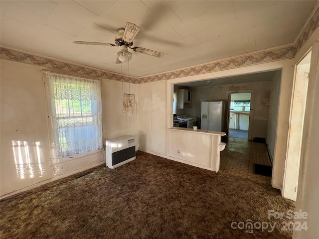 unfurnished living room with dark colored carpet and ceiling fan