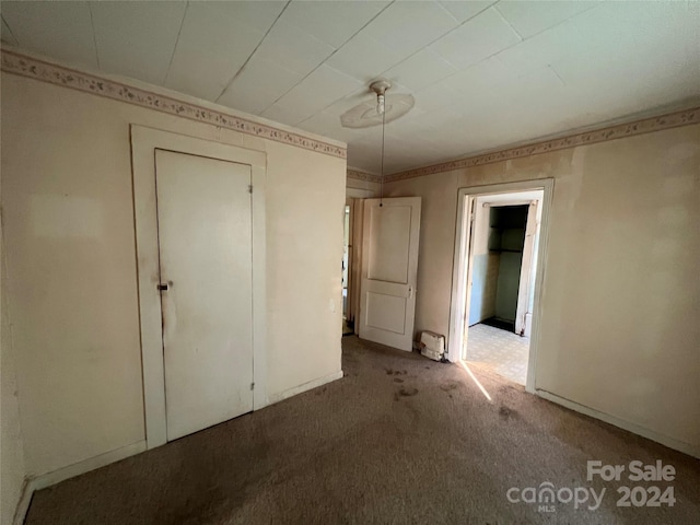 unfurnished bedroom featuring a closet and carpet flooring