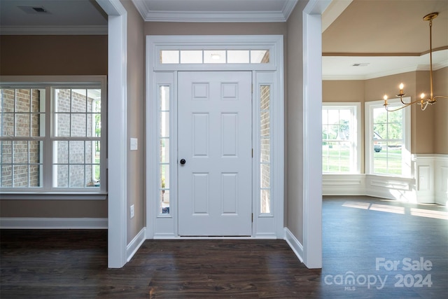 foyer entrance with crown molding, a chandelier, and dark hardwood / wood-style flooring