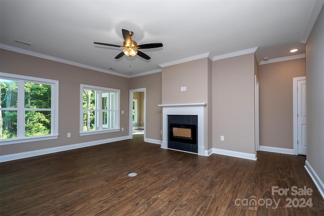 unfurnished living room with crown molding, a tiled fireplace, dark hardwood / wood-style floors, and ceiling fan