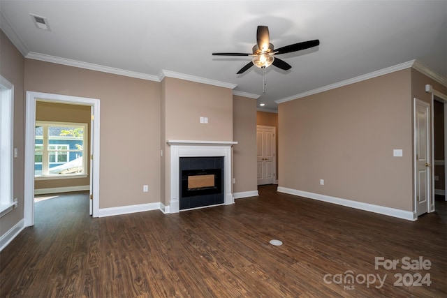 unfurnished living room with crown molding, dark wood-type flooring, ceiling fan, and a tiled fireplace