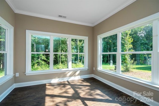 spare room featuring a healthy amount of sunlight, wood-type flooring, and ornamental molding