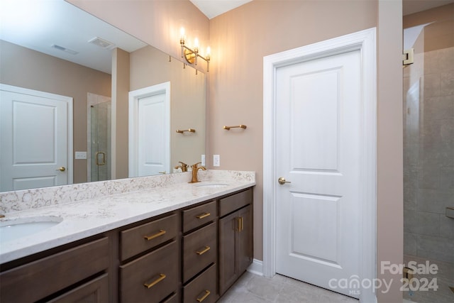 bathroom with dual vanity, tile patterned floors, and walk in shower