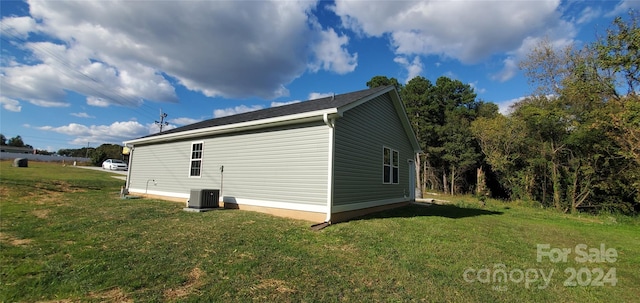 view of property exterior featuring central air condition unit and a lawn