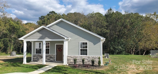 view of front of home with central AC, covered porch, and a front lawn