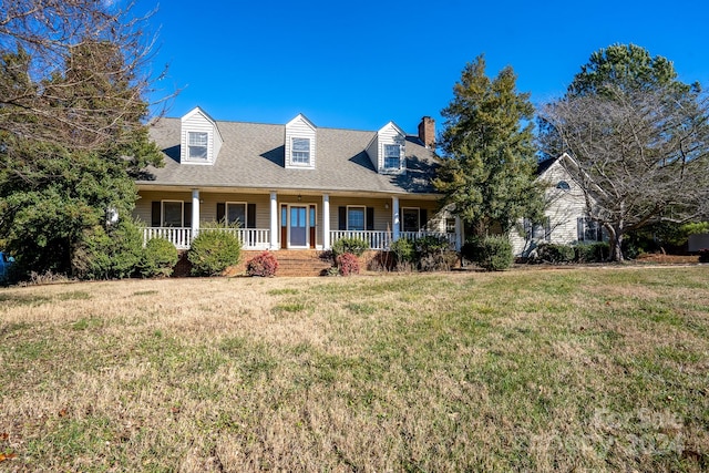 new england style home featuring a front lawn and a porch